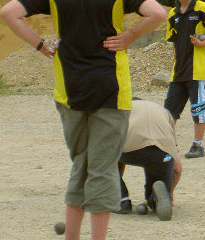 Arbitre de pétanque mesurant devant les jeunes